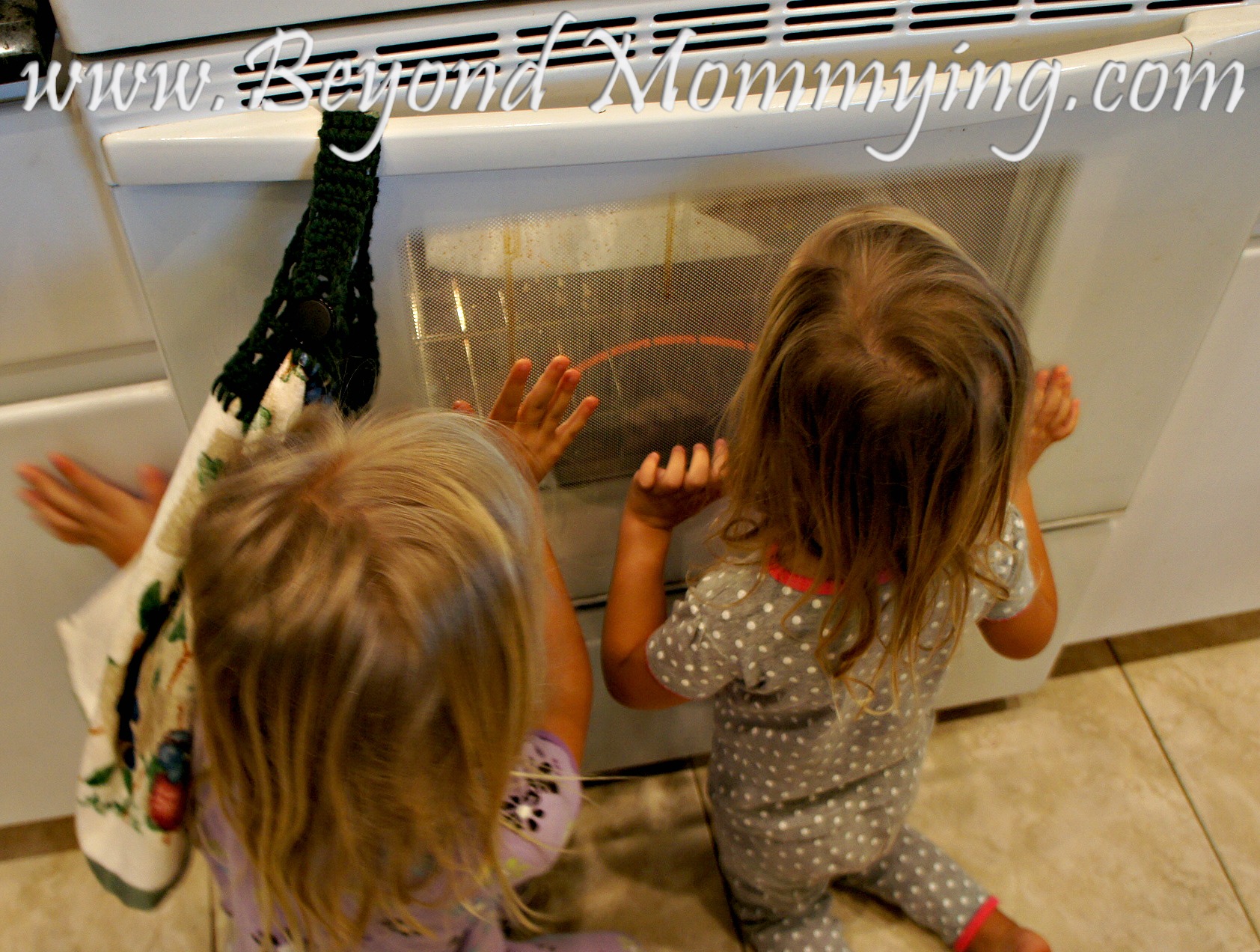 girls peeking in oven